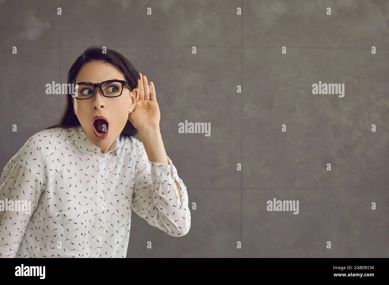 Femme avec une expression choquée tient sa main à l'oreille et entend la  conversation Photo Stock - Alamy