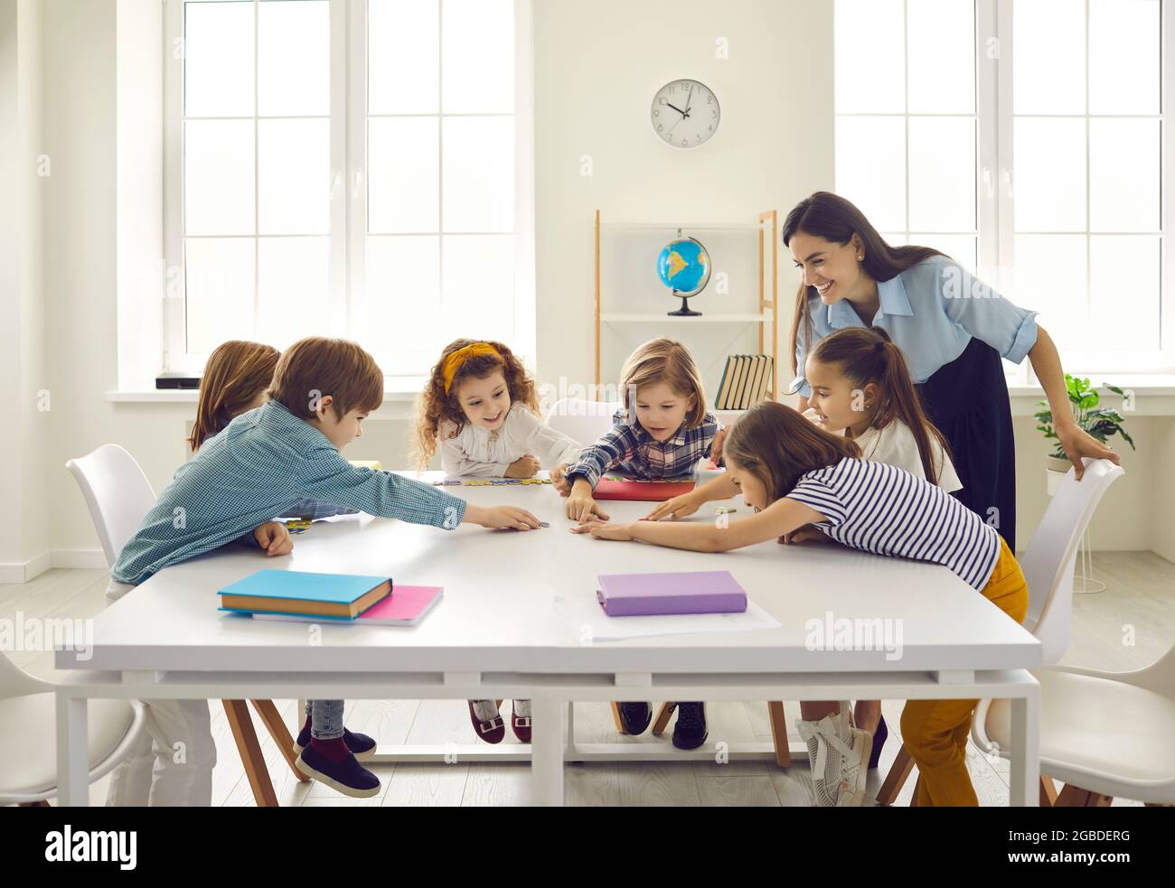 Joyeux enseignant d'école et petits enfants ayant une classe et apprenant de nouvelles lettres Banque D'Images