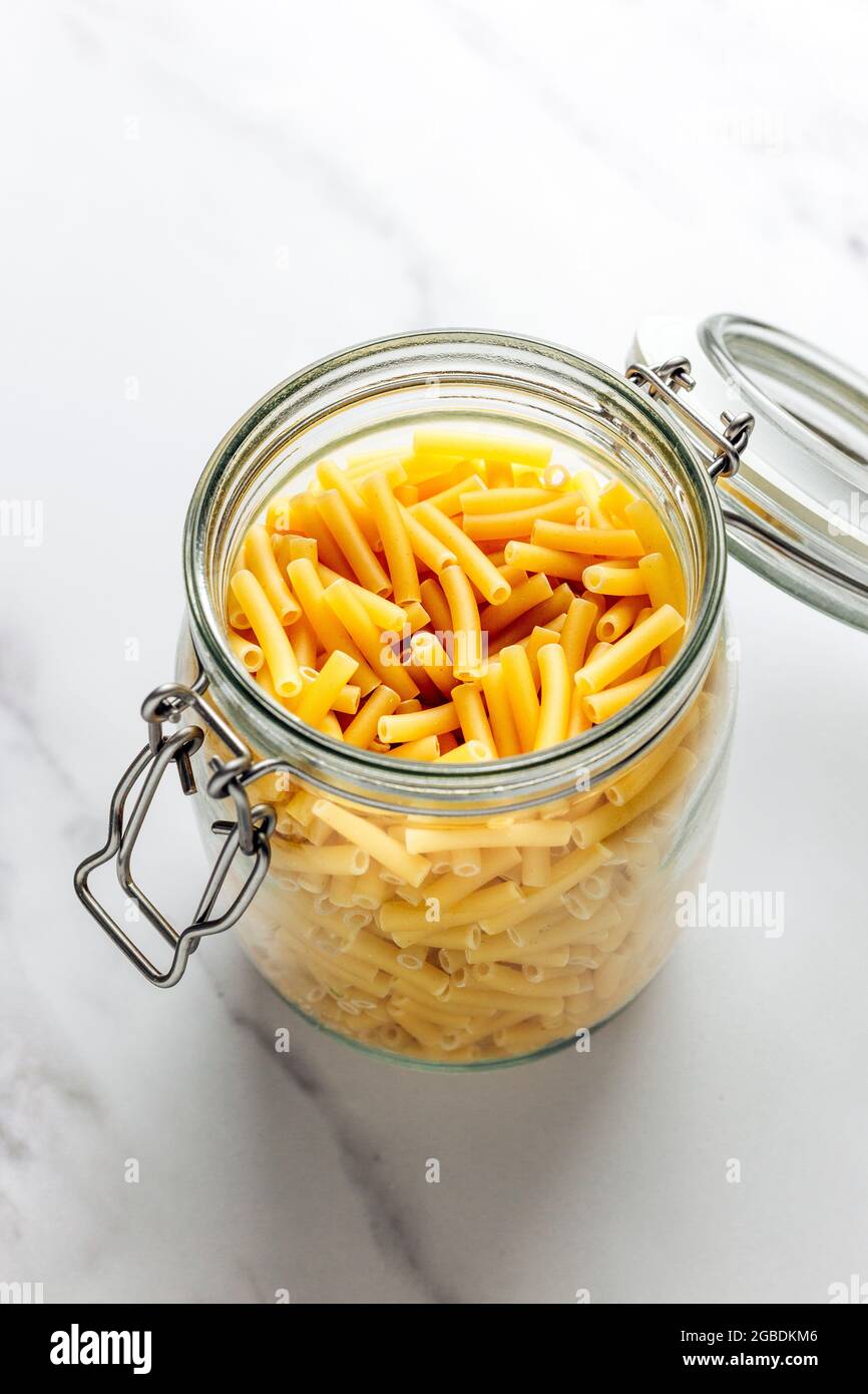 Pâtes de Macaroni séchées dans un pot – COPYSPACE - blanc FOOPPIX Banque D'Images