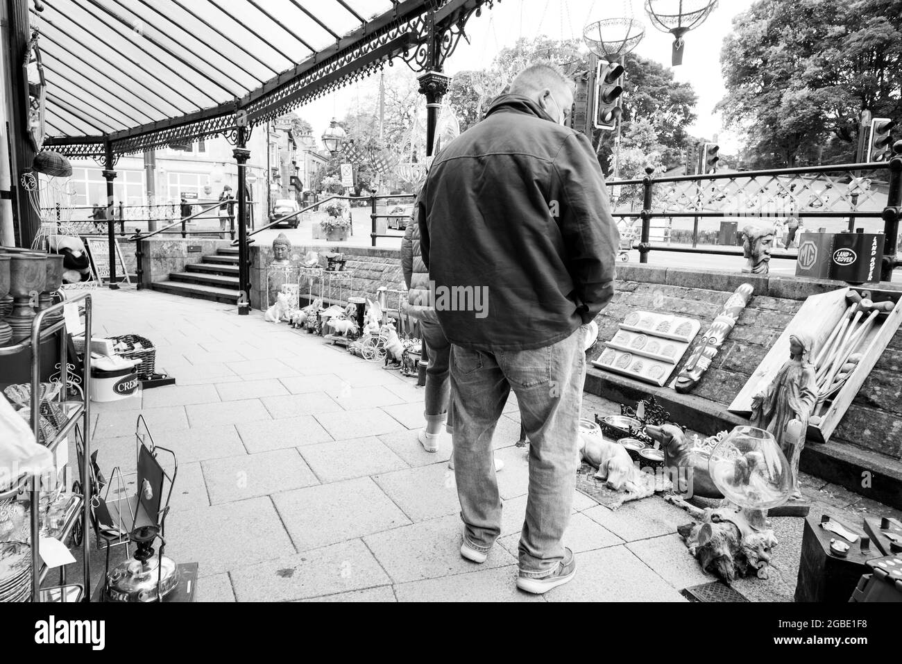 Couple parcourant un écran à l'extérieur d'un magasin bric a brac Banque D'Images