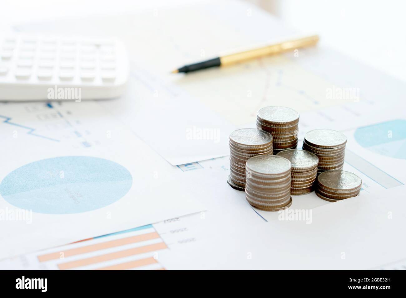 Calculatrice stylo et pièces de monnaie sur le rapport financier. Banque D'Images