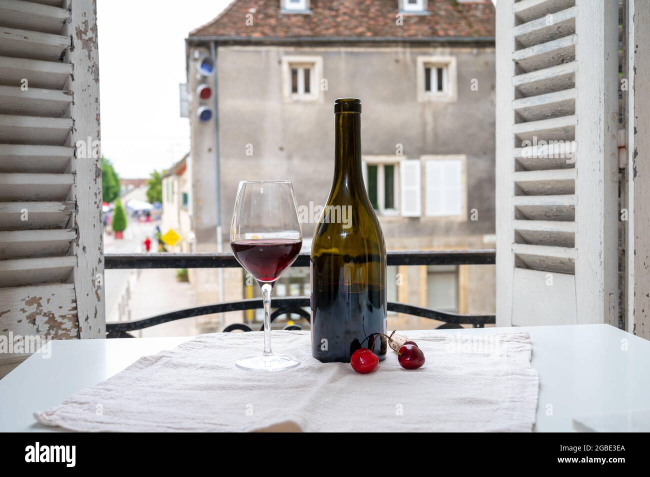 Dégustation de vin rouge bordeaux des grands vignobles cru Pinot noir, verre et bouteille de vin rouge et vue sur la vieille ville dans la région viticole de Bourgogne, F Banque D'Images