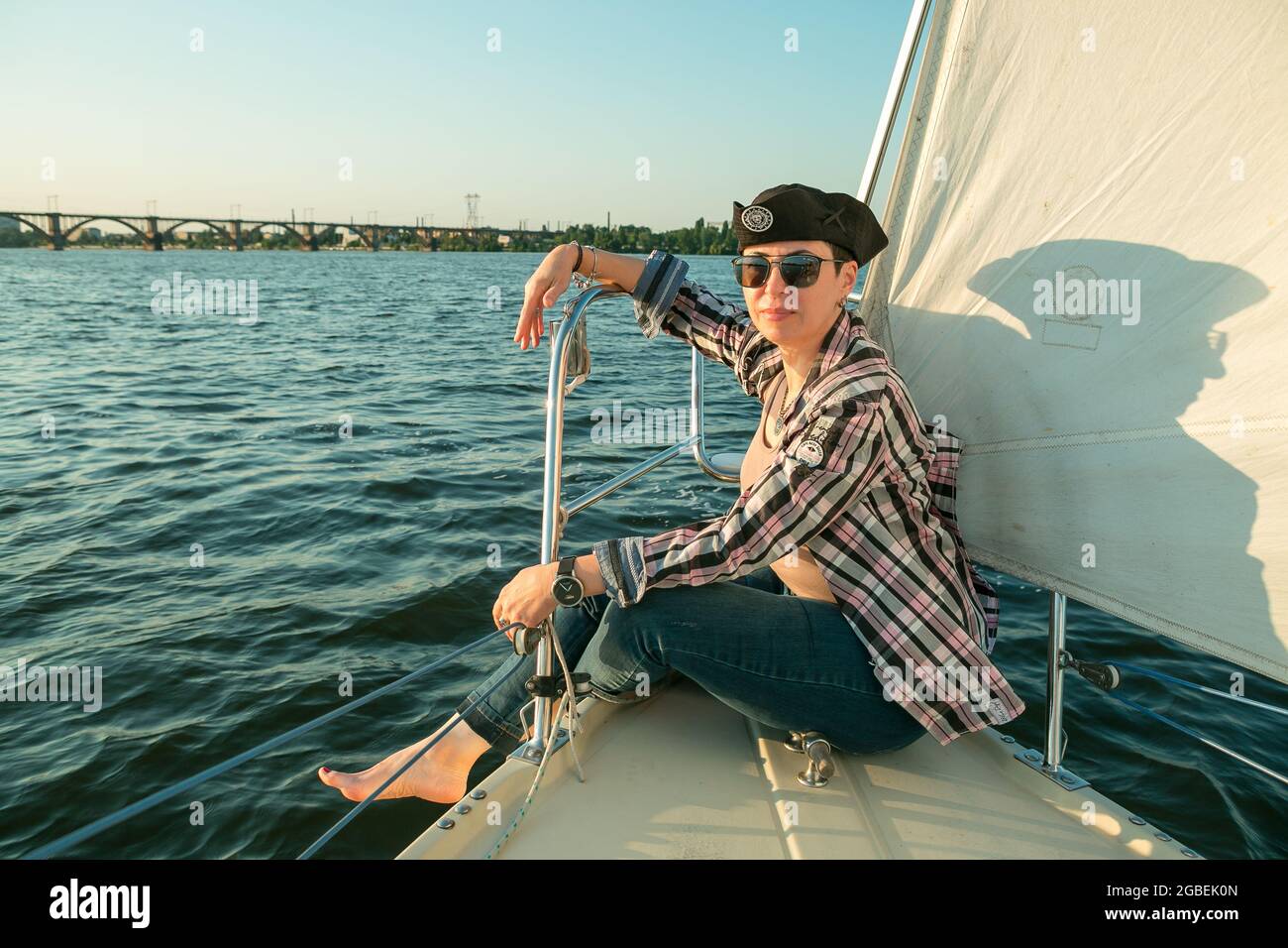 Un luxueux yacht vacances. Bonne belle femme d'âge moyen dans des lunettes de soleil sur le pont de bateau flotte sur la rivière. Banque D'Images