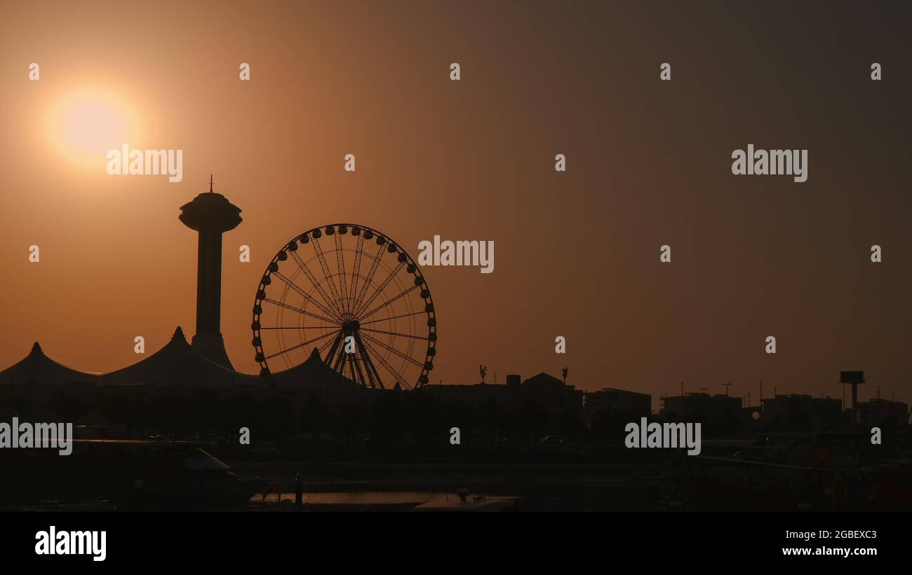 Les silhouettes de la tour du centre commercial Marina et du port de ferris de Marina Eye se mettent au coucher du soleil. Banque D'Images