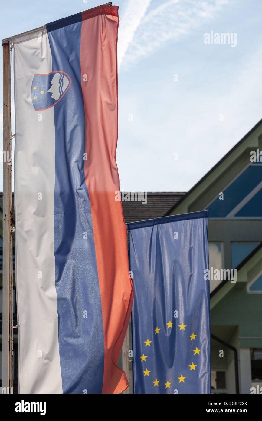 Photo du drapeau de la Slovénie et du drapeau de l'UE ensemble devant un bâtiment de Ljubljana. La Slovénie est l'un des principaux membres de l'Europe Banque D'Images