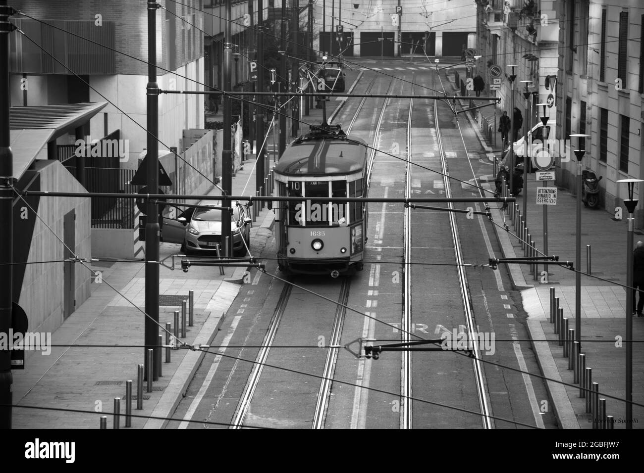 Prise de vue en niveaux de gris d'un paysage urbain avec un ancien tramway dans une rue étroite de la ville Banque D'Images