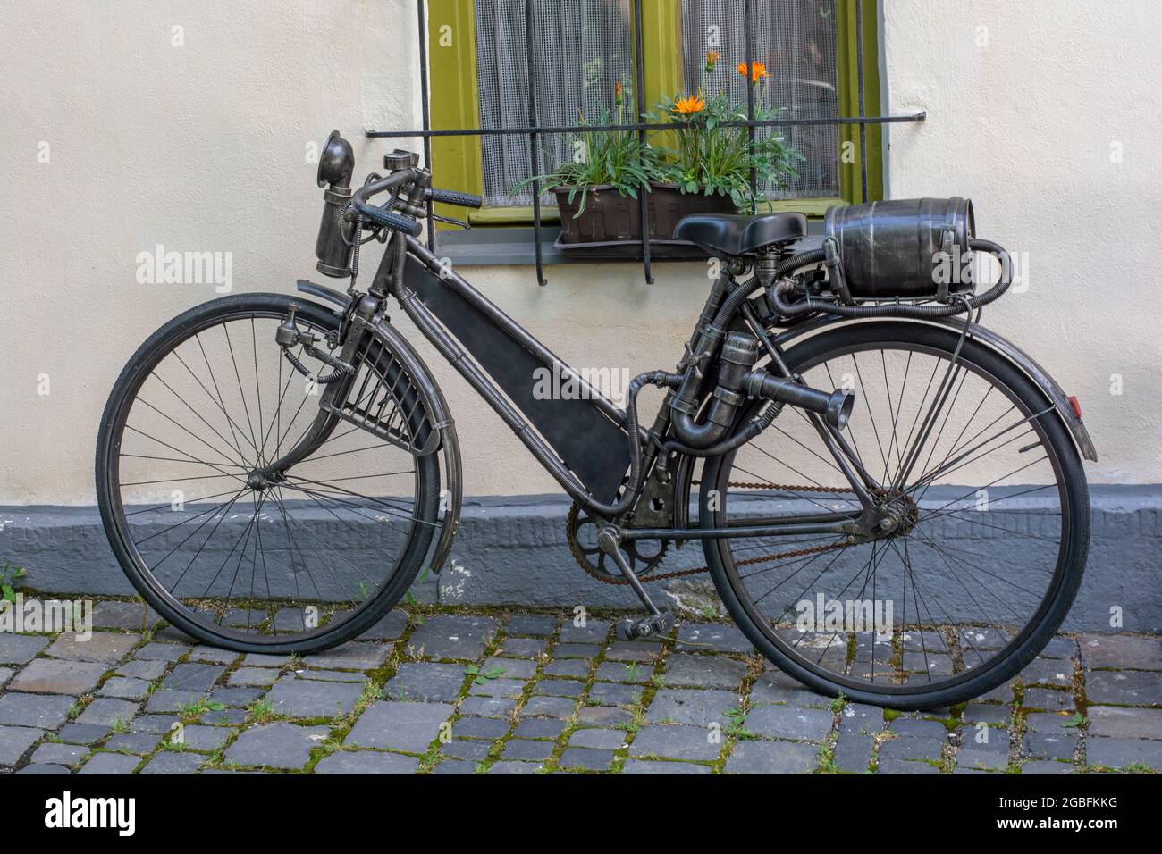 Un vieux vélo antique avec réservoir de carburant en forme de baril de vin attaché à la crémaillère arrière. Vélo d'époque en métal à essence. Gros plan. Détails. Banque D'Images