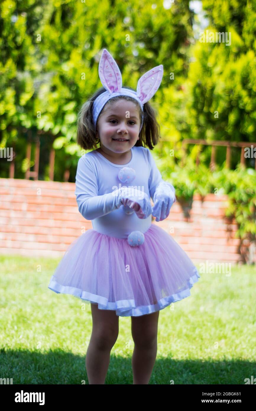 une petite fille en costume de lapin a un pique-nique dans le jardin de sa  maison Photo Stock - Alamy