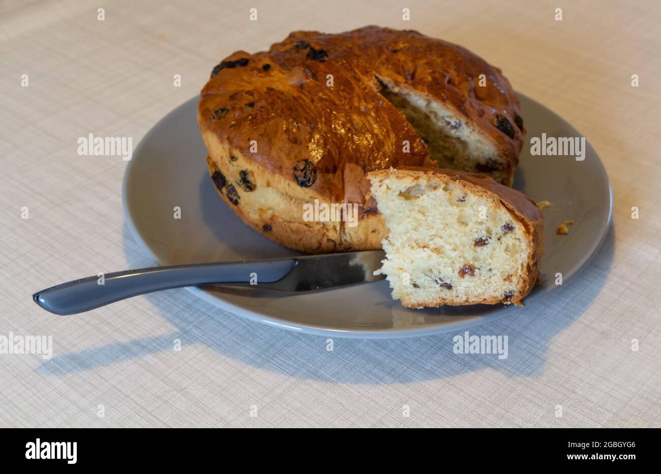 Kouign des gras gâteau avec une pièce coupée et un couteau sur un plat Banque D'Images