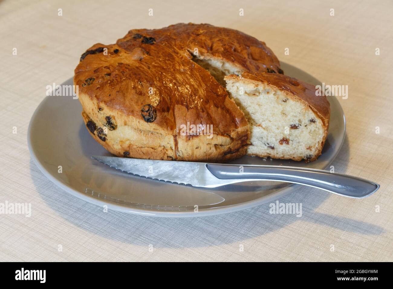 Kouign des gras gâteau avec un morceau coupé et un couteau sur un plat Banque D'Images