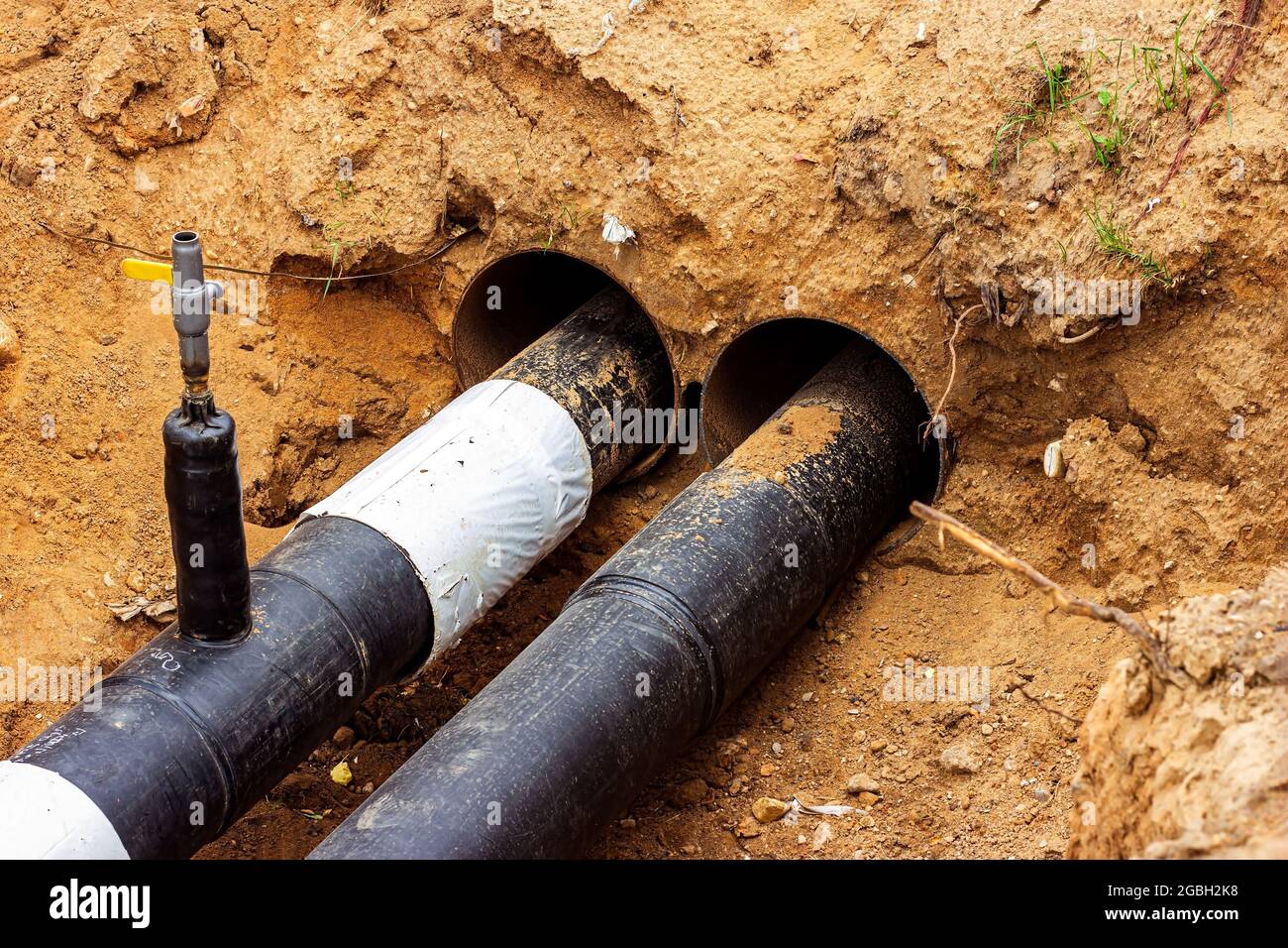 Installation du boîtier de distribution du réseau de chauffage et d'alimentation en eau. Cadre de raccordement des tuyaux dans la tranchée du sol. Banque D'Images