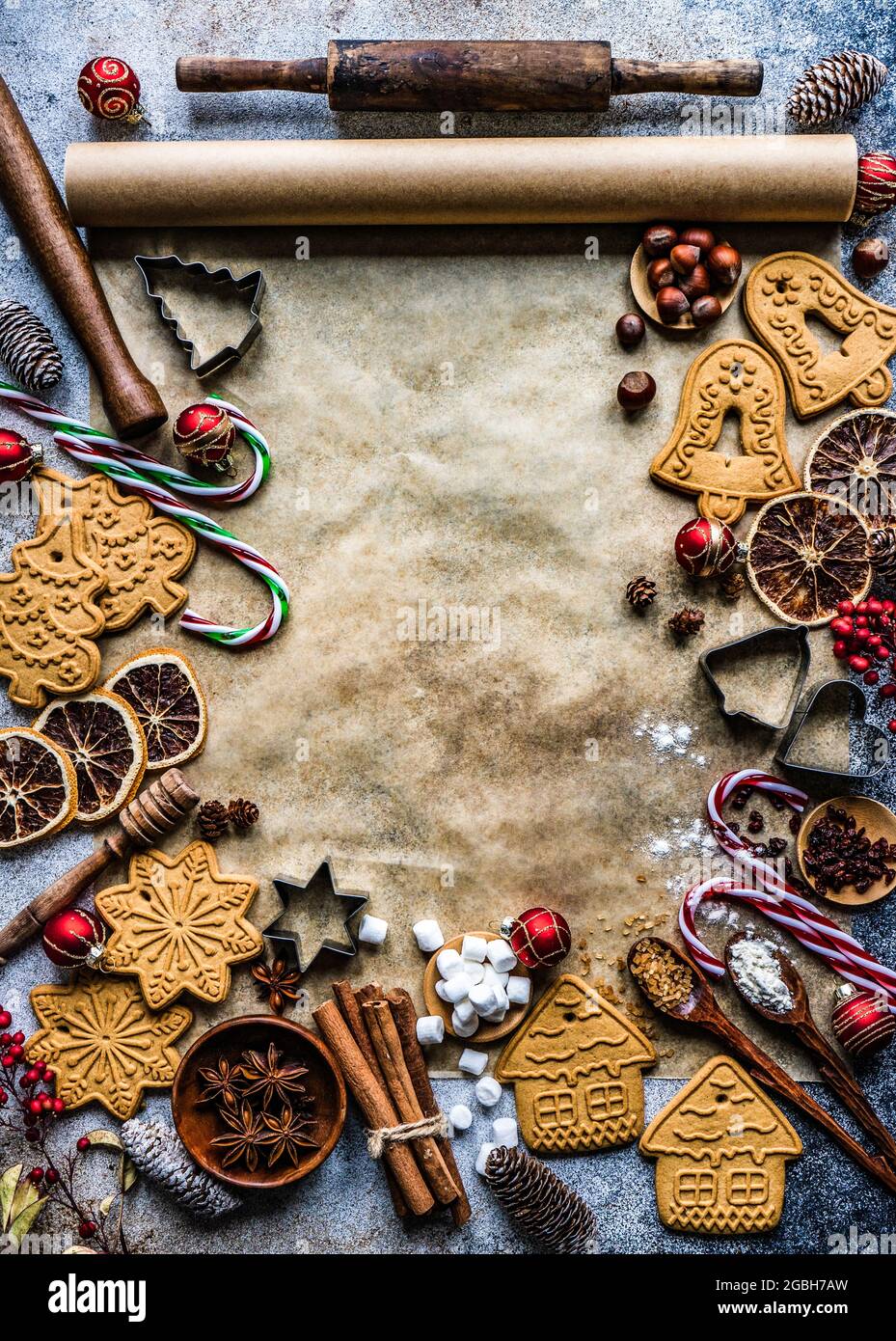 Assortiment de biscuits de pain d'épice de Noël, d'épices et de matériel de cuisine sur papier à pâtisserie Banque D'Images