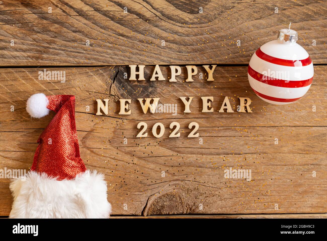 Bonne Annee 22 Lettres En Bois Citation Avec Chapeau De Pere Noel Rouge Etincelant Et Boule Rayee Sur Table En Bois Carte De Vœux Festive Pour Un Nouvel An Photo Stock Alamy