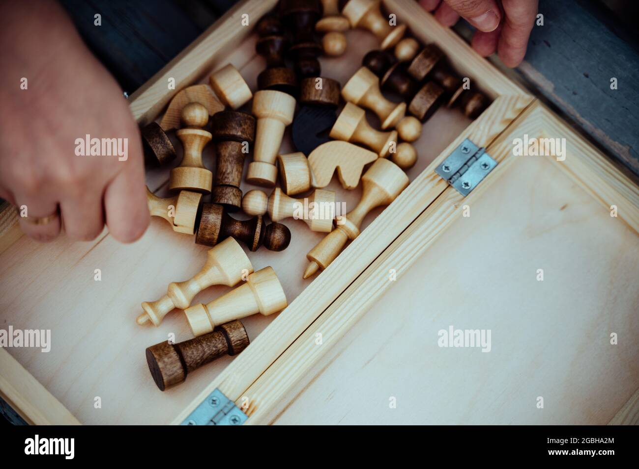 Gros plan des pièces d'échecs et des mains de la femme méconnaissable. Une femme inconnue tient des figures d'échecs dans ses mains Banque D'Images