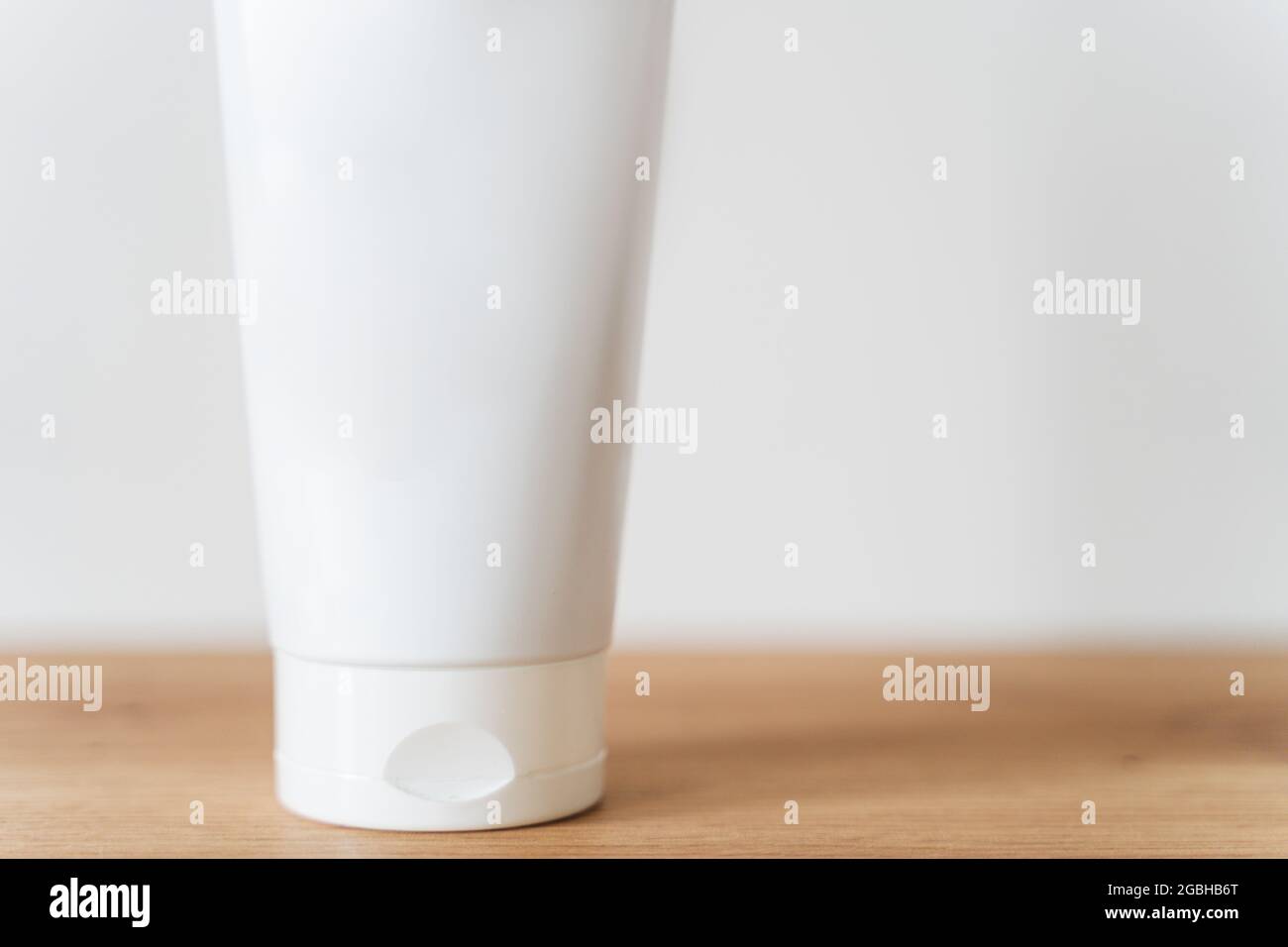 Maquette de tube blanc crème sur une table en bois. Banque D'Images