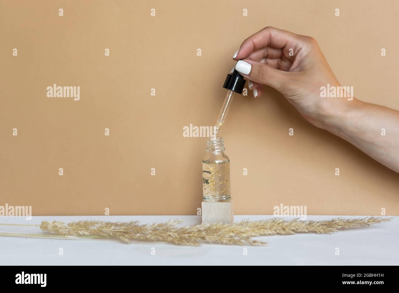 Une femme tient un compte-gouttes de la bouteille avec du sérum ou de l'huile essentielle naturelle Banque D'Images