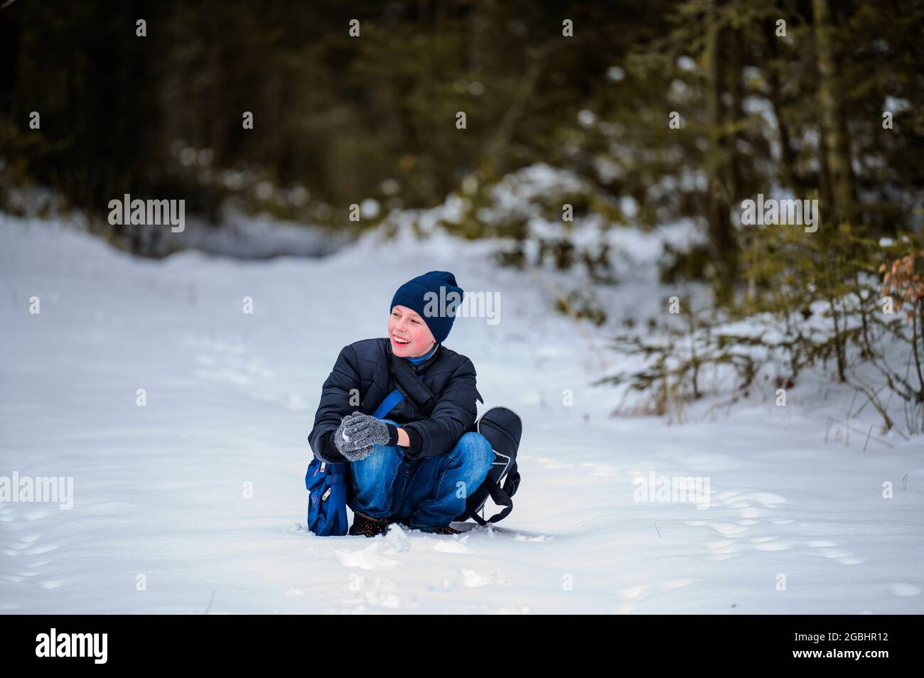 Le gars est assis sur la neige dans les bois, une promenade d'hiver dans les  bois.New Photo Stock - Alamy