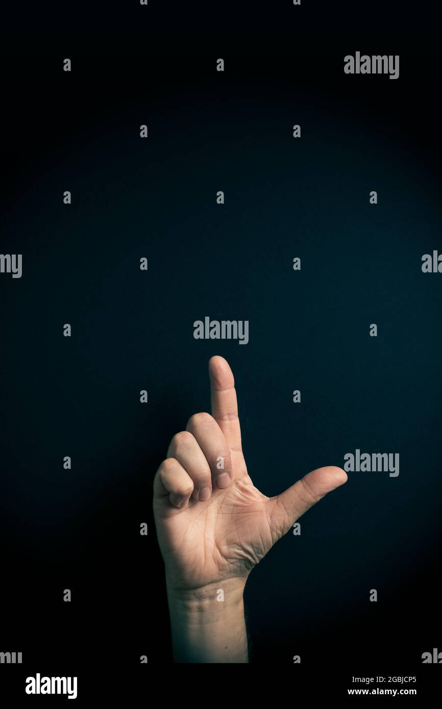 Image couleur dramatique de la main masculine démontrant l'ASL American Sign Language lettre L avec espace de copie vide pour les éditeurs Banque D'Images