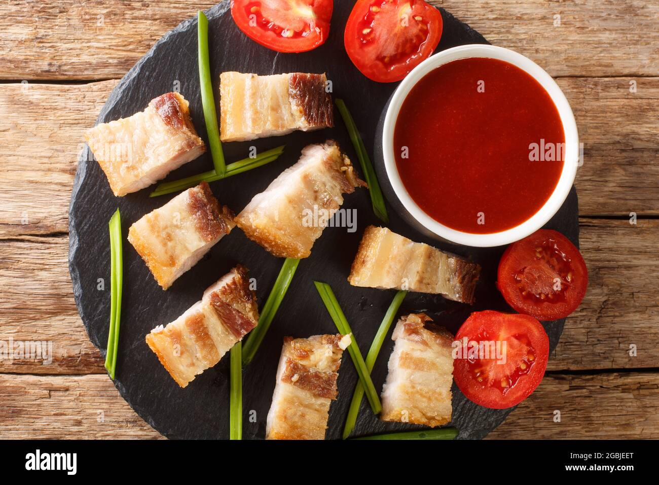 Le ventre de porc croustillant au lit de lechon kawali est un délicieux plat Filippino dans le plat d'ardoise sur la table. Vue horizontale du dessus Banque D'Images