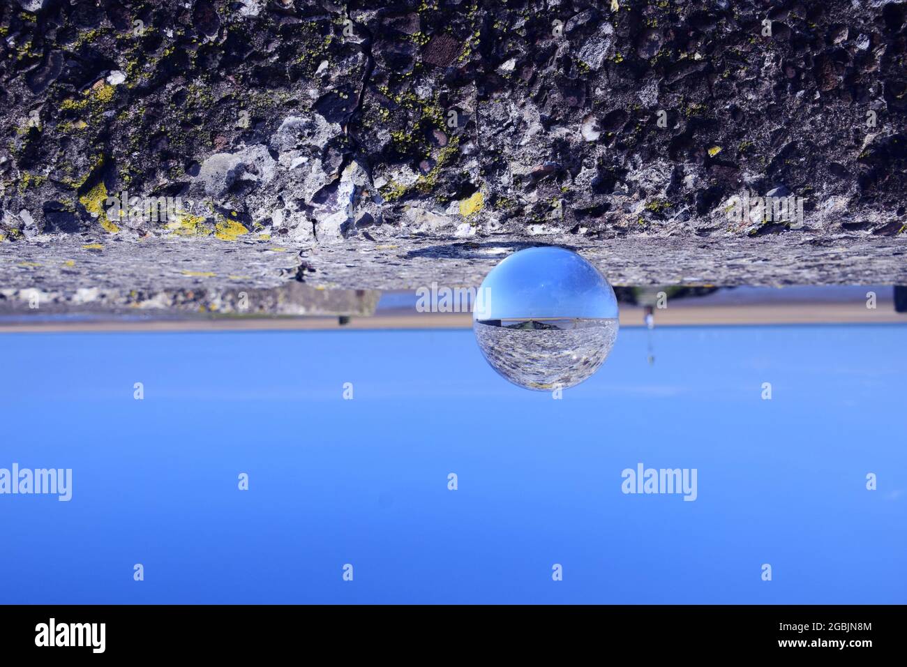 La marée est sur la rive de l'estuaire de Mersey montrant des bancs de sable exposés, des oiseaux de mer, un affluent de la rivière Alt sous le ciel bleu et la lumière du soleil d'été. Banque D'Images