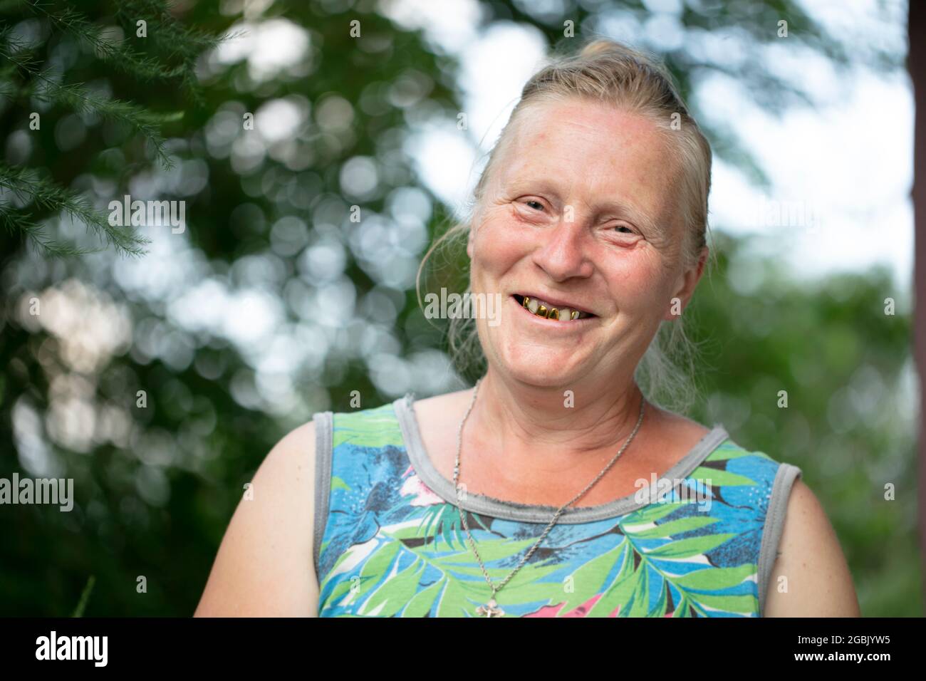 Portrait d'une femme âgée aux dents dorées qui rit et regarde l'appareil photo. Banque D'Images