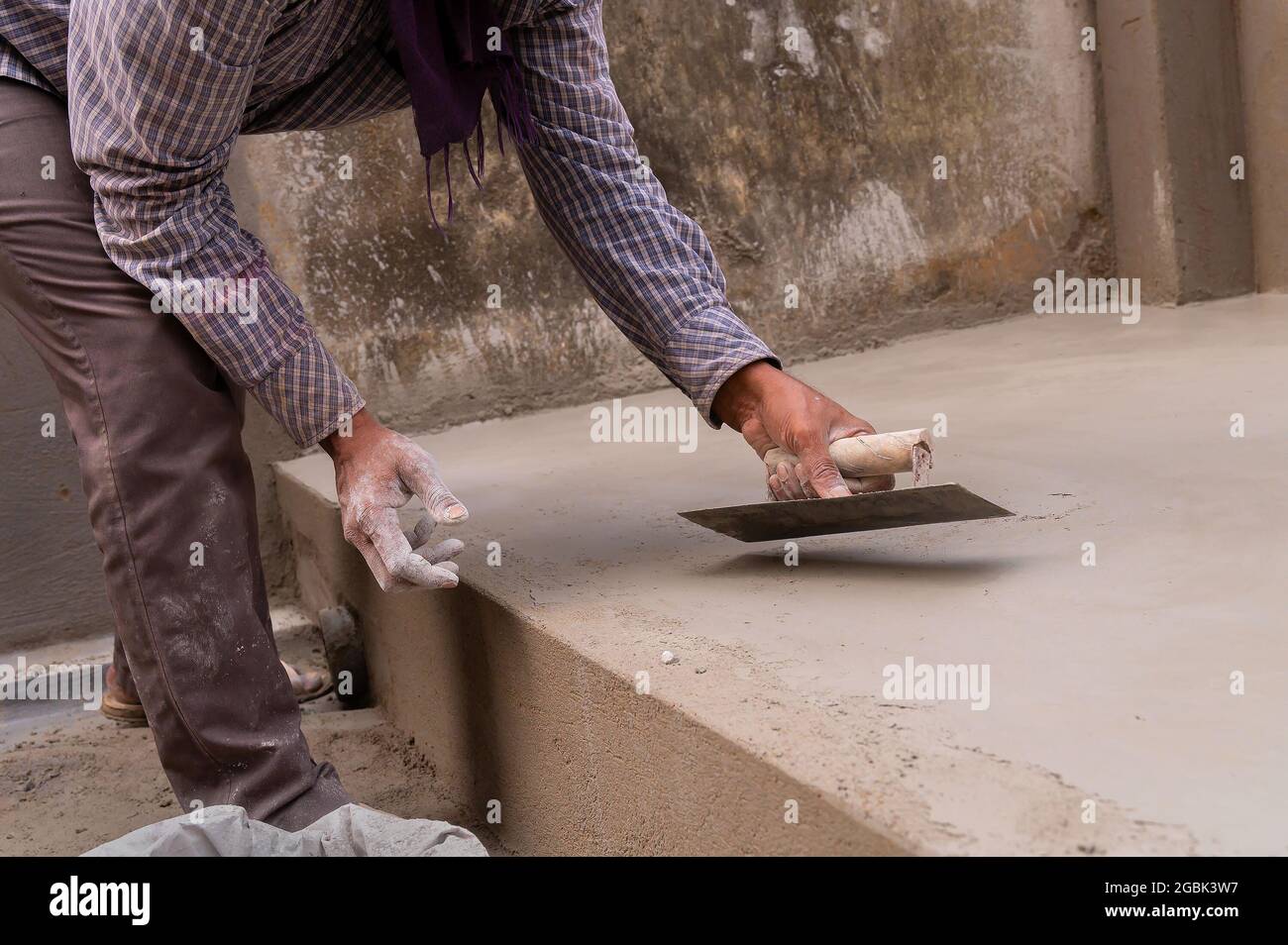 Travail indien nivellement plancher en plâtre à l'aide de truelle plate et  de ciment manuellement, image de stock Photo Stock - Alamy