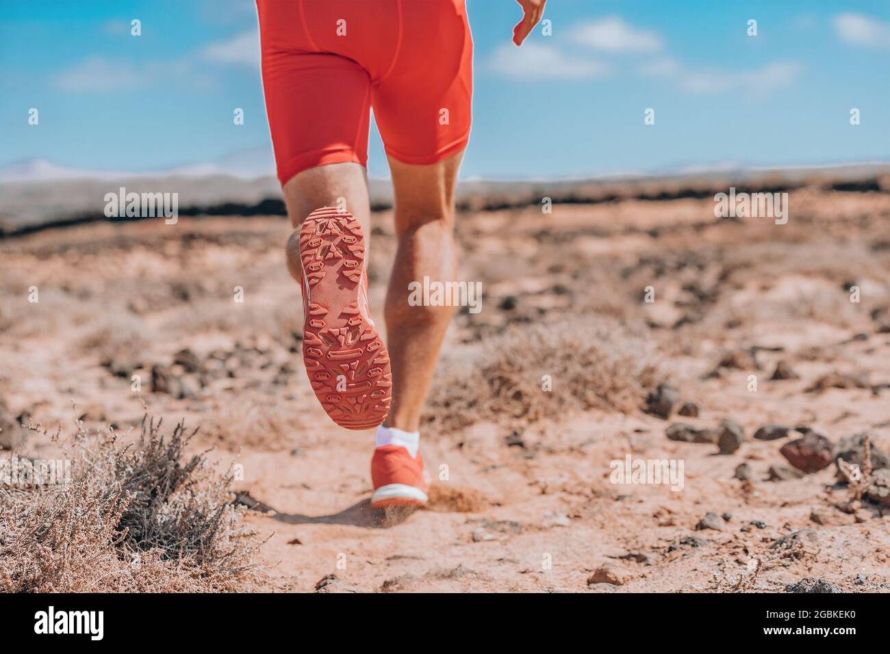 Coureur sprinting courir loin vue arrière gros plan de chaussures rouges. Entraînement triathlon athlète sur piste entraînement d'endurance en plein air Banque D'Images