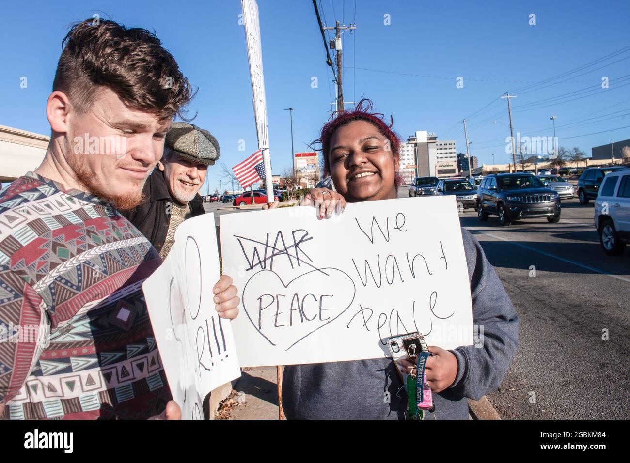 01-04-2020 Tulsa USA - trois manifestants multiculturels et souriants de génération avec panneaux anti-guerre se trouvent près de l'intersection Banque D'Images