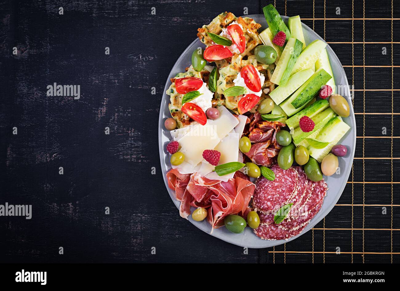 Carte de charcuterie. Plateau: parmesan au prosciutto, salami, concombres et olives. Assortiment de hors-d'œuvre savoureux ou d'antipasti. Vue de dessus, espace de copie, Banque D'Images