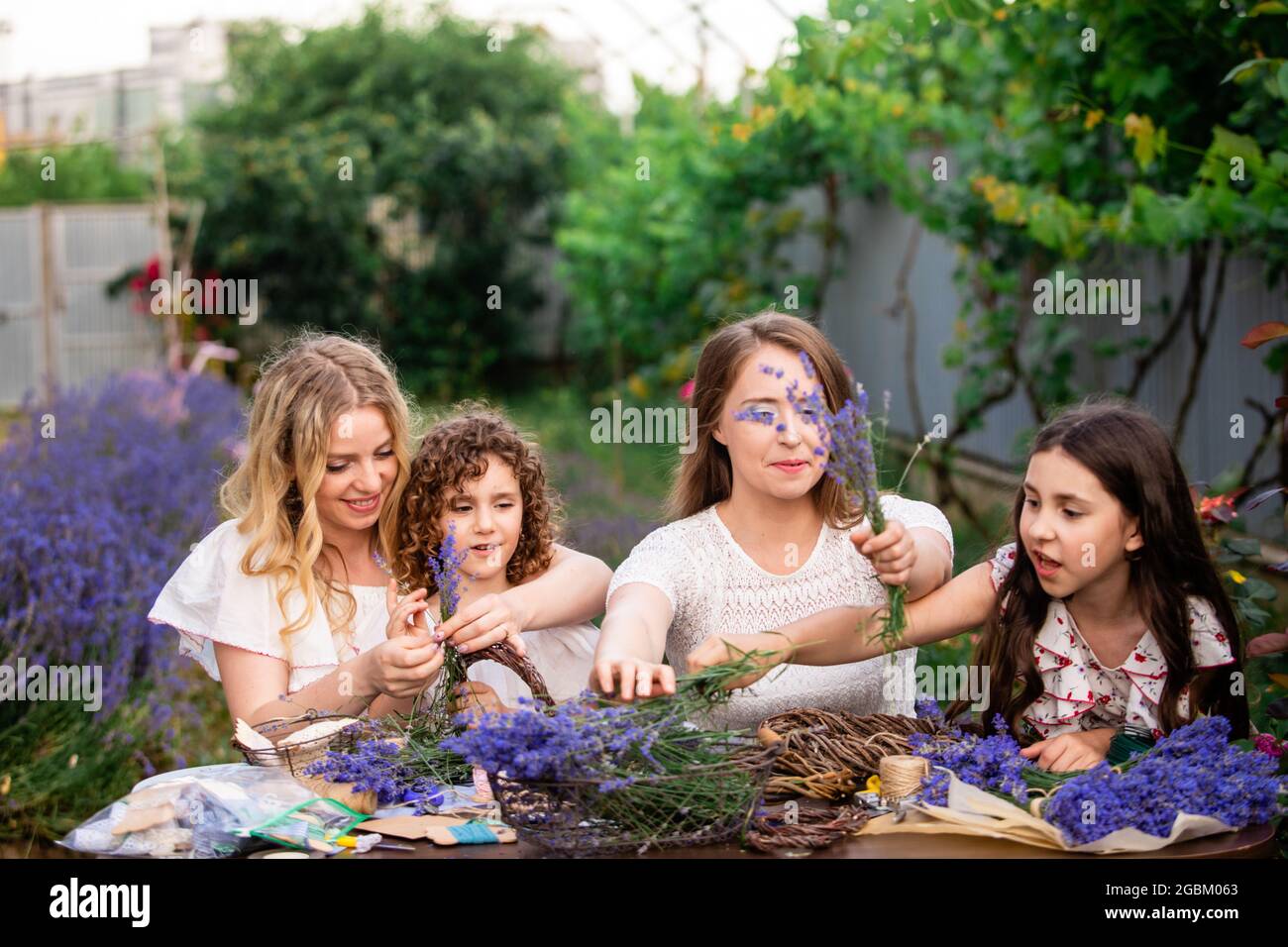 Femmes avec des filles faisant des bouquets de lavande à l'extérieur Banque D'Images
