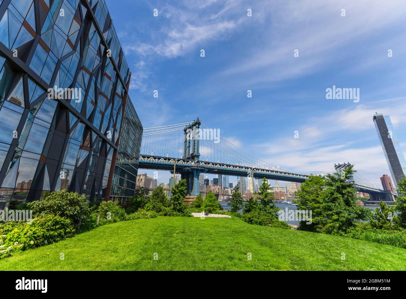 Le pont de Manhattan se dresse au-delà de l'East River depuis la pelouse du Brooklyn Bridge Park, au milieu de la pandémie de COVID-19, le 20 juin 2021 à New York City, aux États-Unis Banque D'Images