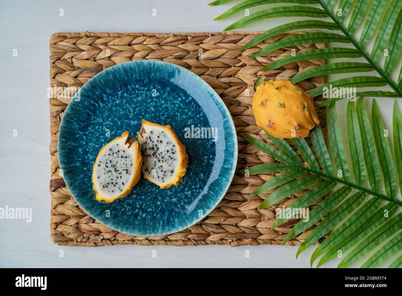 pitaya jaune dragonfruit en tranches présentées sur une assiette bleue sur la table. Fruit de dragon bio frais et sain. Hylocereus megalanthus Banque D'Images