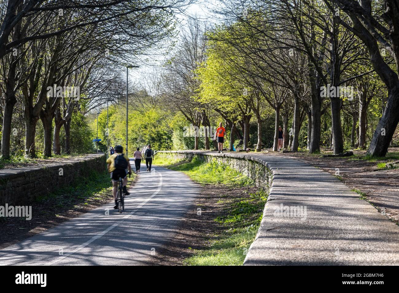 Les cyclistes surprennent les arbres sur les quais de la gare de Mangotsfield sur le chemin de fer de Bristol et de Bath lors d'une journée de printemps ensoleillée. Banque D'Images