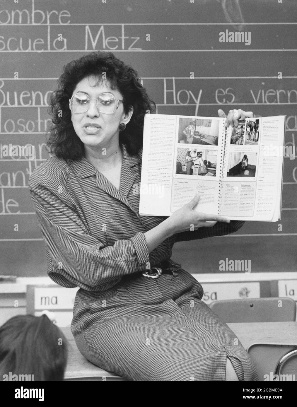 Austin Texas USA, vers 1990: Femme hispanique bilingue enseignant d'éducation travaillant avec des élèves de maternelle dans la classe publique primaire. ©Bob Daemmrich Banque D'Images