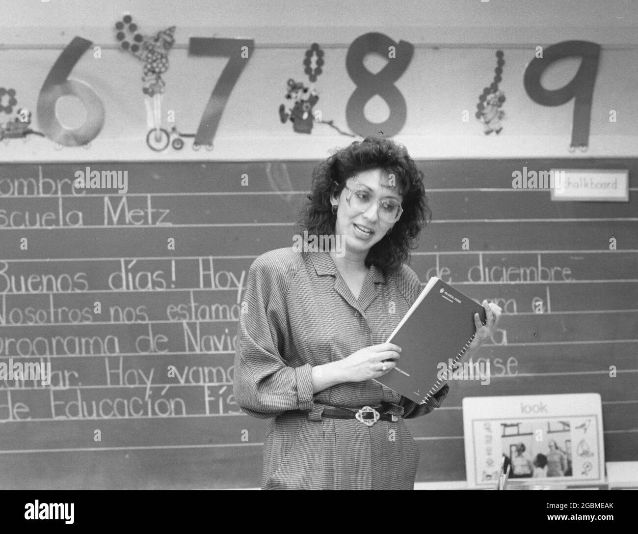 Austin Texas USA, vers 1990: Femme hispanique bilingue enseignant d'éducation travaillant avec des élèves de maternelle dans la classe publique primaire. ©Bob Daemmrich Banque D'Images