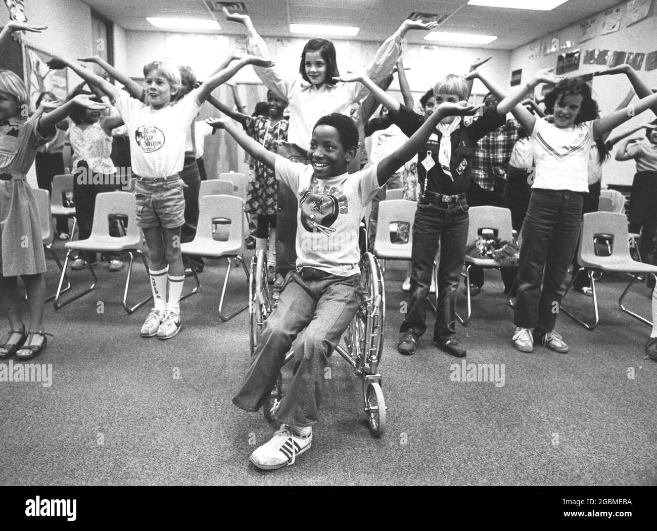 Austin, Texas États-Unis, vers 1984: Garçon de 4e année Patrick Skeaton, qui a spina bifida et a dû avoir une jambe amputée alors qu'en 3e année. L'histoire photo le montre pendant une journée typique à l'école; ici, il participe à des exercices d'étirement avec les camarades de classe. ©Bob Daemmrich Banque D'Images