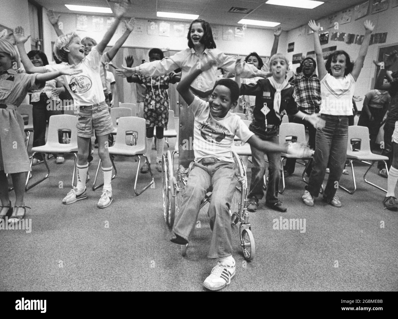 Austin, Texas États-Unis, vers 1984: Garçon de 4e année Patrick Skeaton, qui a spina bifida et a dû avoir une jambe amputée alors qu'en 3e année. L'histoire photo le montre pendant une journée typique à l'école; ici, il participe à des exercices d'étirement avec les camarades de classe. ©Bob Daemmrich Banque D'Images