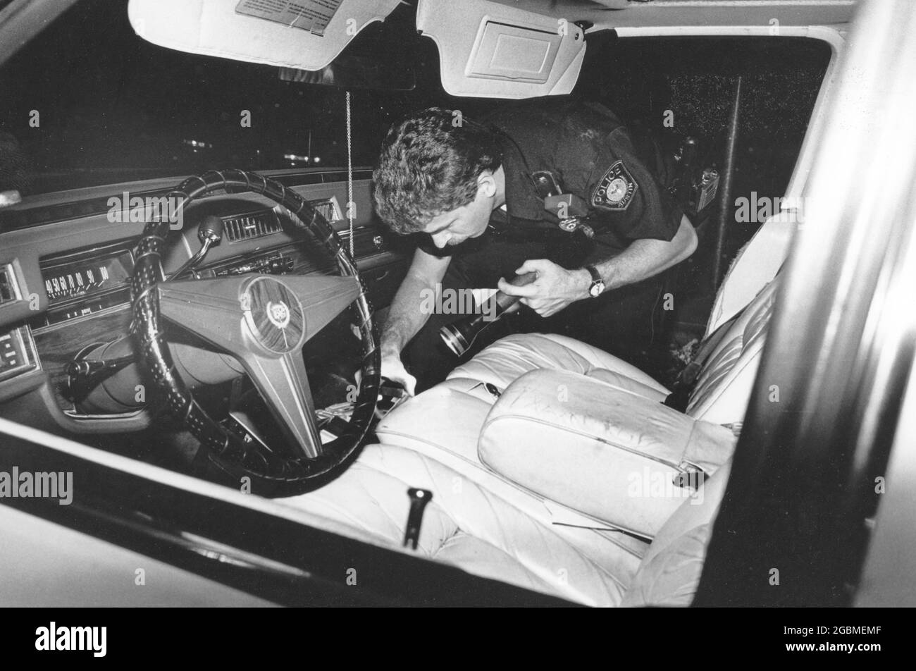 Austin Texas USA, vers 1990: Un policier blanc cherche une voiture dans la majorité Black East Austin. ©Bob Daemmrich Banque D'Images