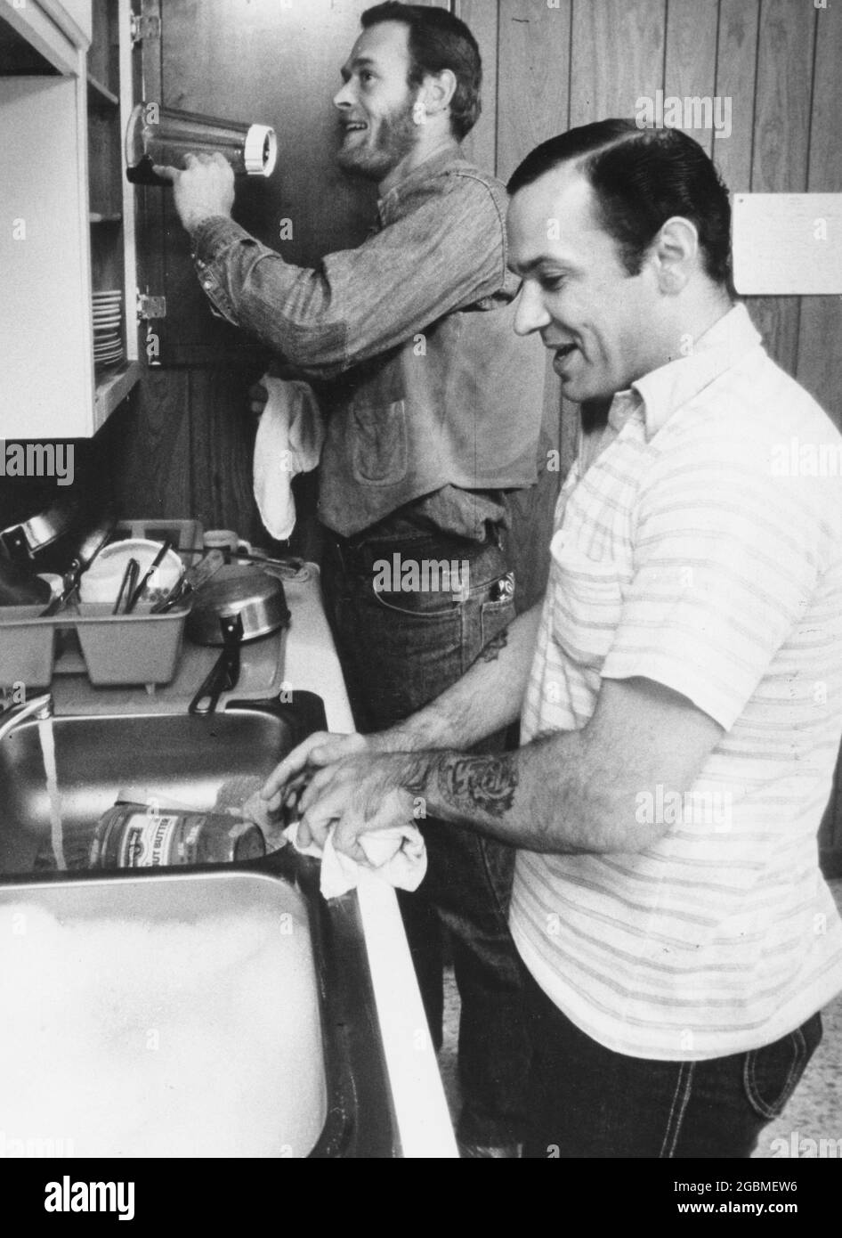 Austin, Texas, États-Unis, circa1990 : les détenus de sexe masculin vivant dans une maison de milieu de maison s'assèchent pour laver et sécher les plats après un repas. AUCUNE version. ©Bob Daemmrich Banque D'Images