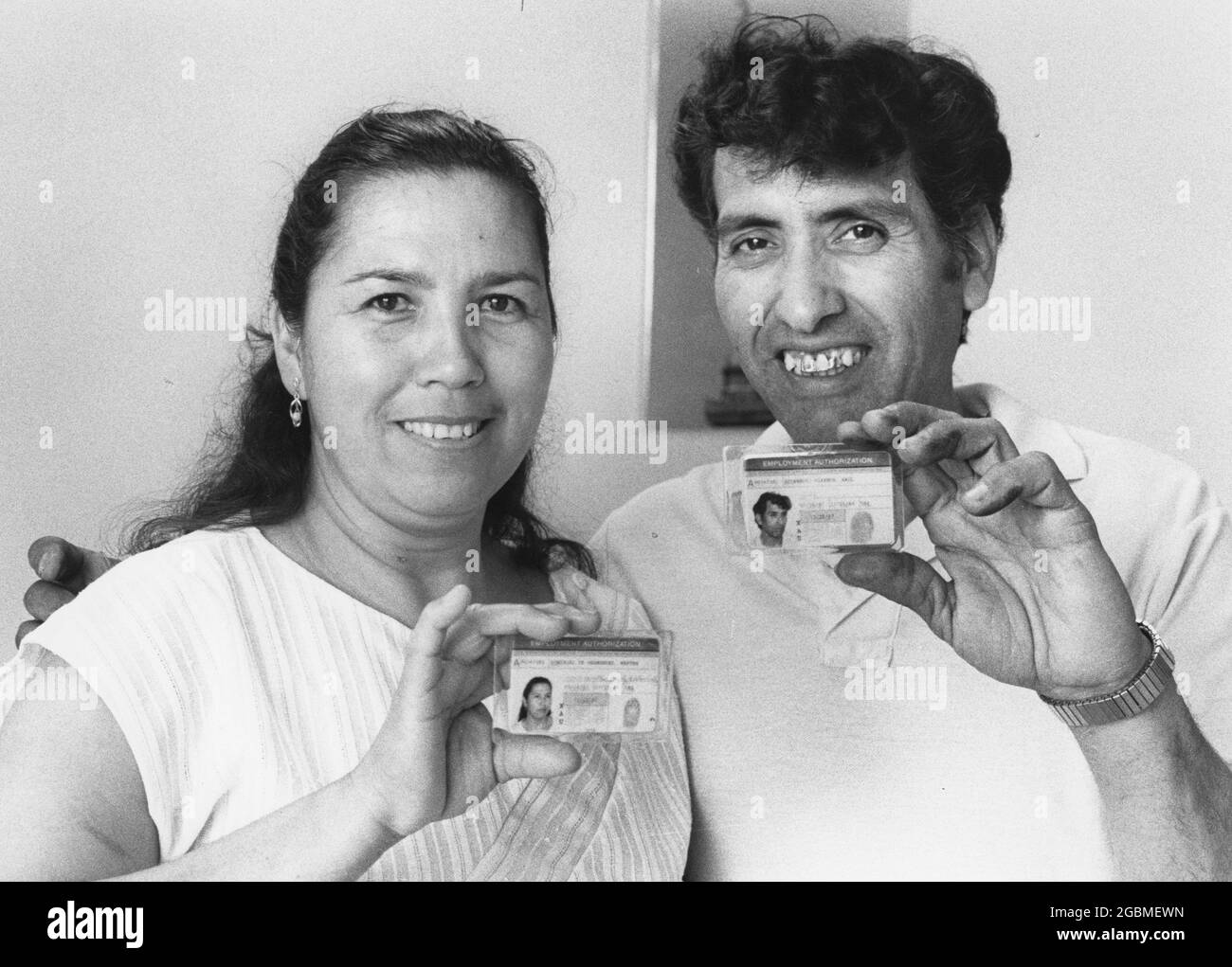 Austin, Texas États-Unis, vers 1990: Les immigrants honduriens sans papiers au Austin Immigration and Naturalization (INS) légalisation Center montrent leurs cartes d'identité après avoir demandé une demande d'amnistie. ©Bob Daemmrich Banque D'Images