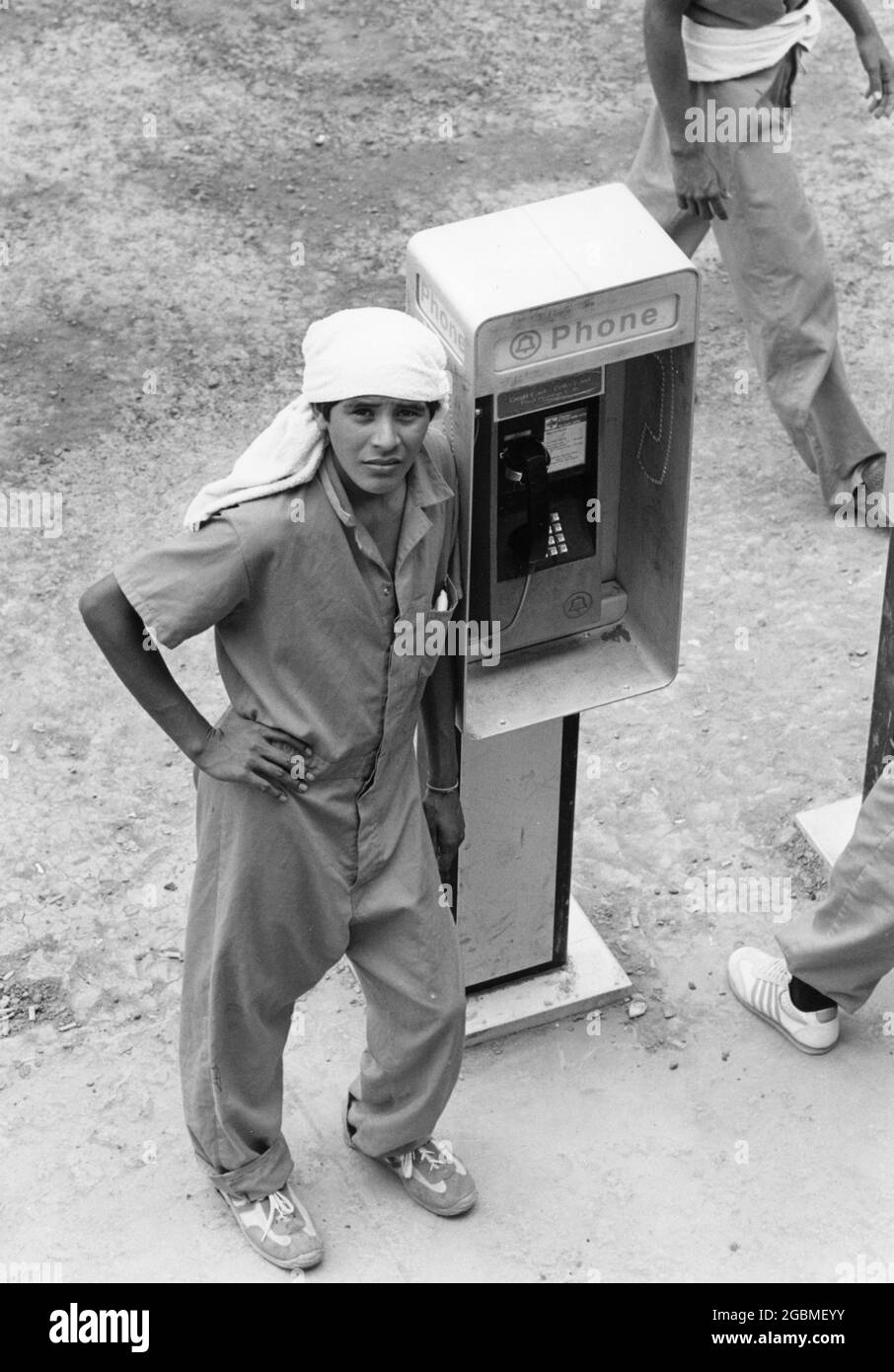 Port Isabel, Texas, États-Unis, circa1989 : les immigrants sans papiers du centre de détention du sud du Texas se réunissent autour de téléphones payants pour appeler des membres de la famille ou un avocat. ©Bob Daemmrich Banque D'Images