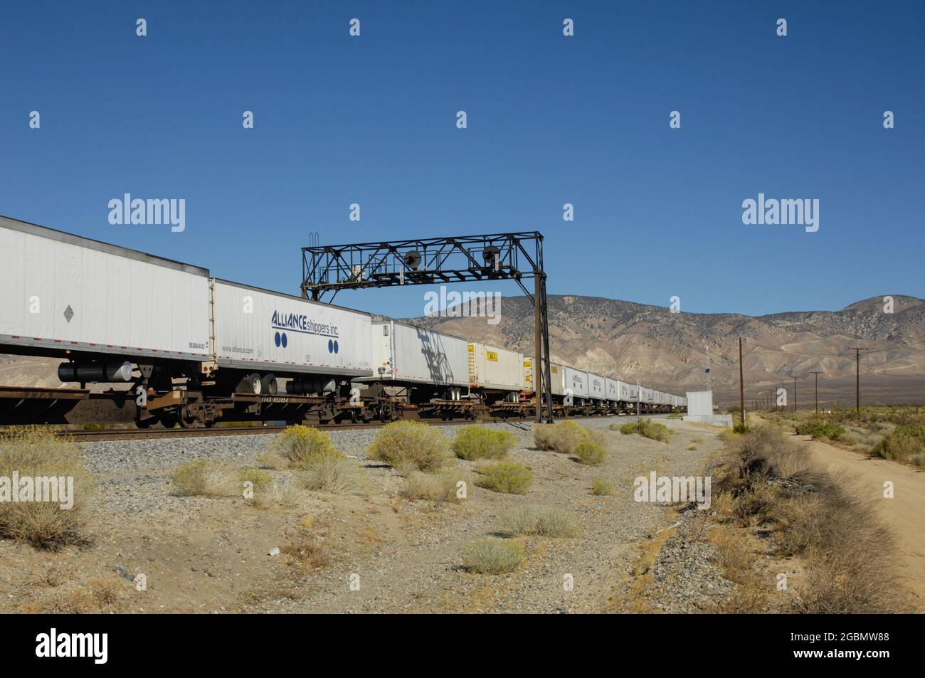 Le train intermodal passe sous le pont de signalisation près de Mojave, Californie/ Banque D'Images
