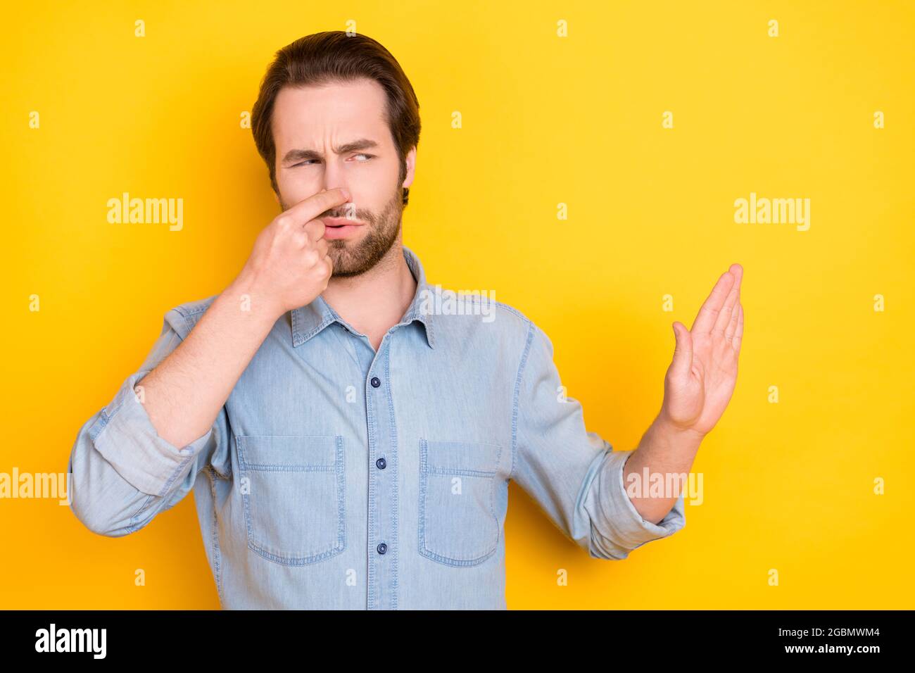 Photo portrait d'un jeune homme regardant l'espace de copie refusant le mauvais parfum laid isolé sur fond jaune vif Banque D'Images