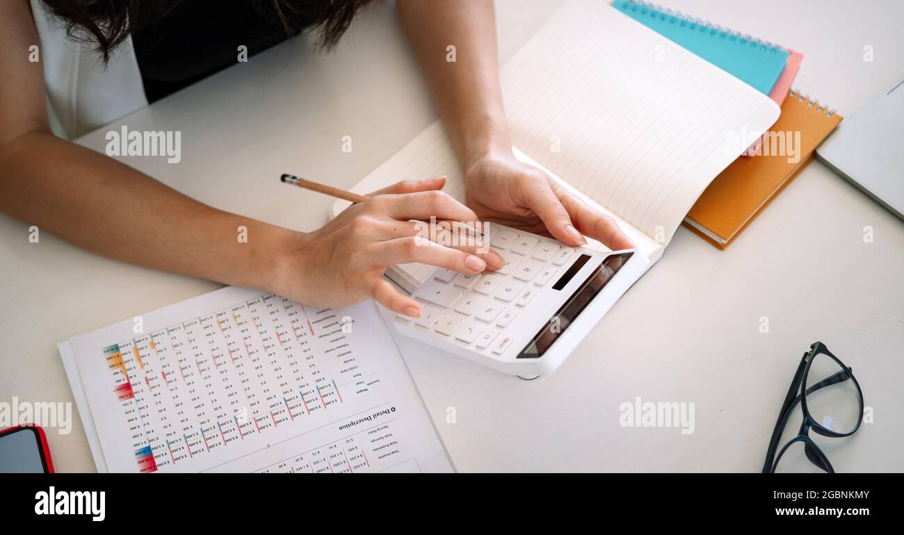 Vue de dessus, Business Woman travaillant la comptabilité financière avec la calculatrice et les données financières Banque D'Images
