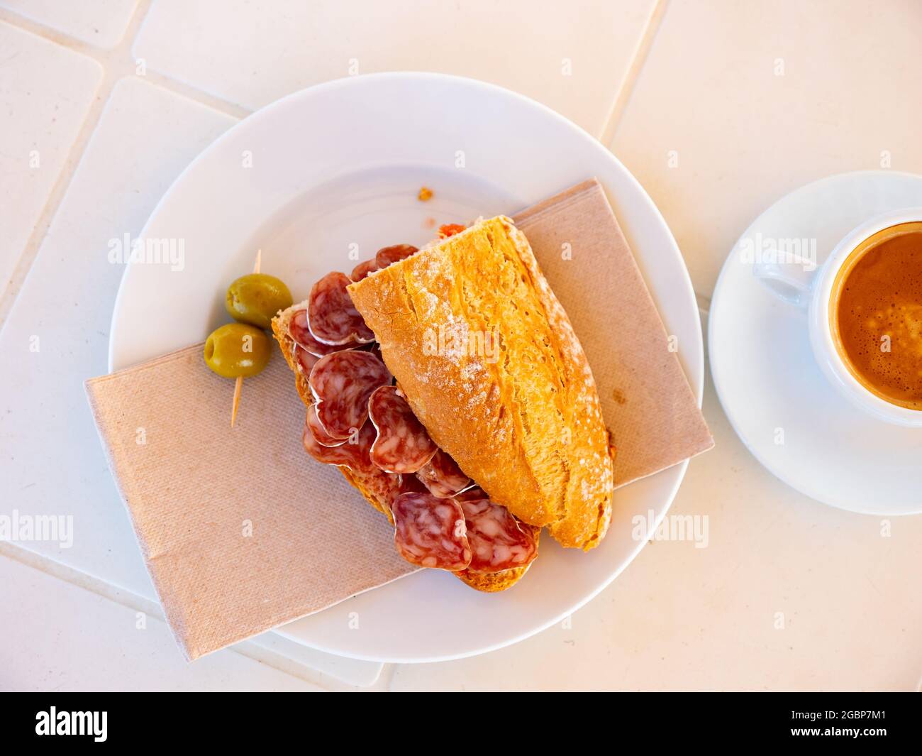 Sandwich avec saucisse de fuet olives. Petit déjeuner espagnol Banque D'Images