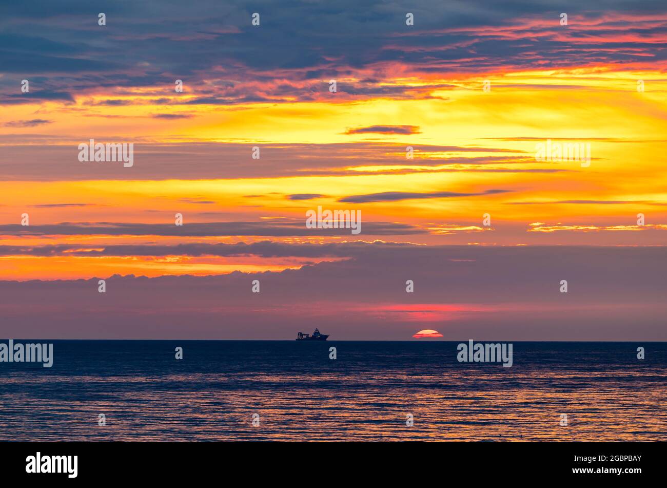 Écosse, Royaume-Uni, 5 août 2021. Lever du soleil : le soleil se lève sur l'horizon avec la silhouette d'un navire dans la mer du Nord Banque D'Images