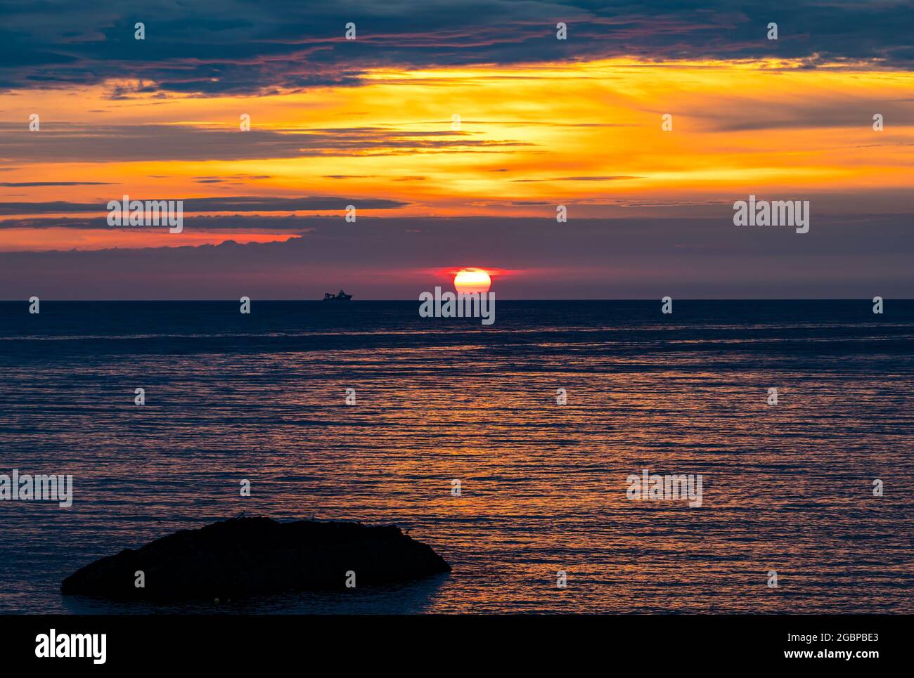 Écosse, Royaume-Uni, 5 août 2021. Lever du soleil : le soleil se lève sur l'horizon avec la silhouette d'un navire dans la mer du Nord Banque D'Images
