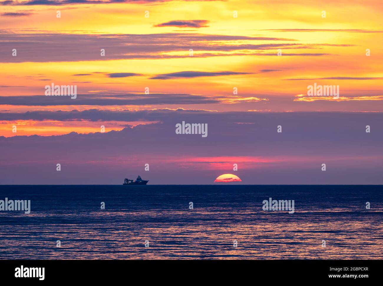 Écosse, Royaume-Uni, 5 août 2021. Lever du soleil : le soleil se lève au-dessus de l'horizon avec la silhouette d'un navire dans trois Mer du Nord Banque D'Images