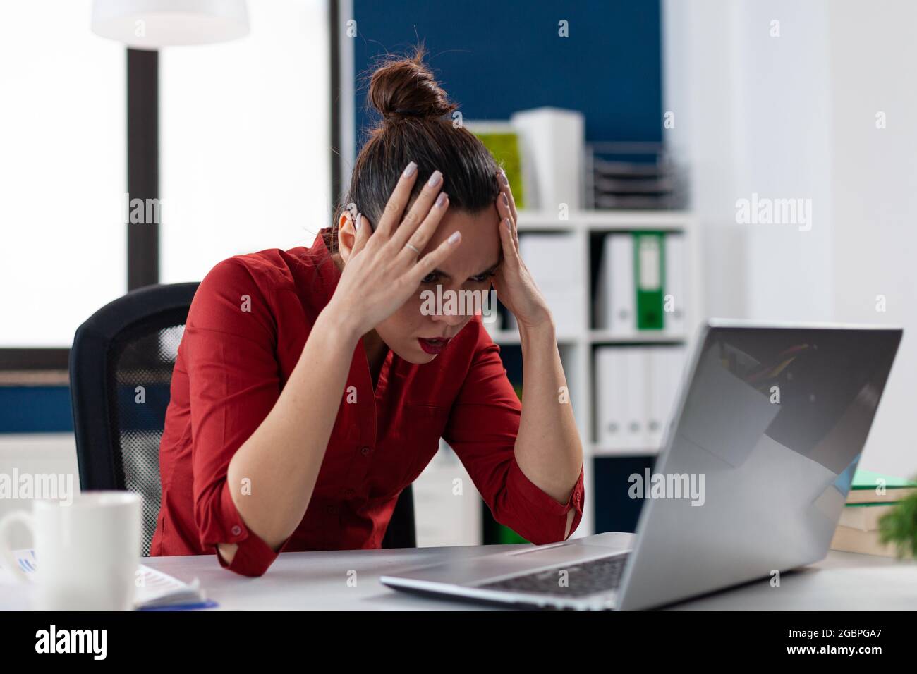 Femme d'affaires frustrée ayant un problème avec un ordinateur portable lent cassé, dans le lieu de travail d'entreprise. Entrepreneur stressé qui a l'air agacé par le travail dur ou l'accident du système. Employé épuisé. Banque D'Images