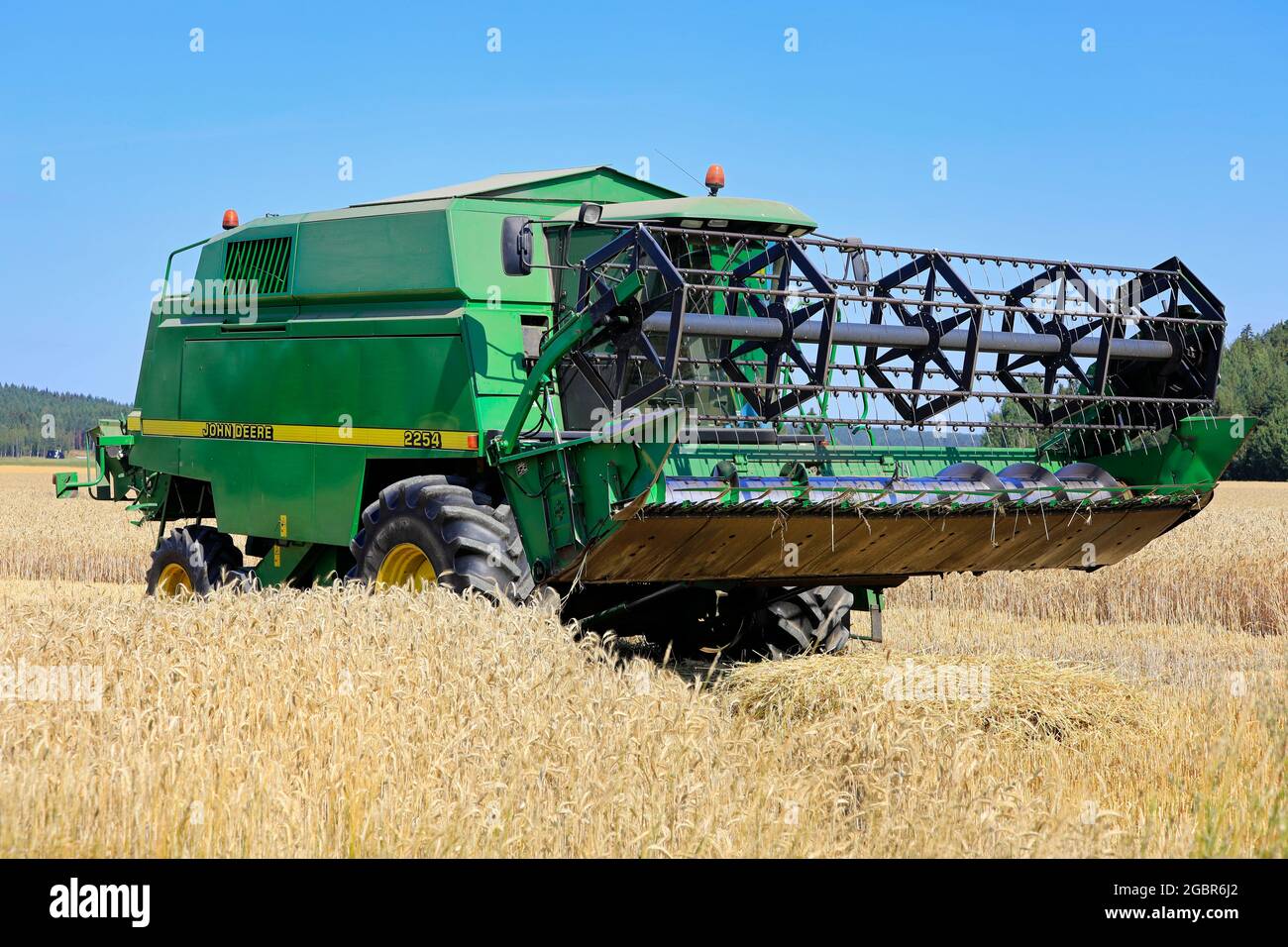 Moissonneuse-batteuse John Deere 2254 dans un champ de seigle, dispositif de coupe vers le haut, le jour ensoleillé de l'été. La saison de récolte commence au début de 2021. Salo, Finlande. 25 juillet 21. Banque D'Images